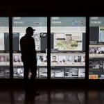 Jason Thompson walks by an interactive exhibit of screens about wars. (Andy Bronson / The Herald)