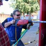 Russ Tilton, left, looks on as coworker James Day drills through a concrete wall to install conduit for the newly installed solar panels Friday afternoon at Marysville Pilchuck High School in Marysville on April 21, 2017. (Kevin Clark / The Herald)