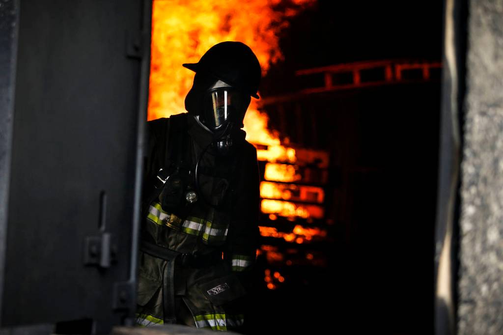 A firefighter walks through a building during an exercise at the Washington State Fire Training Academy near North Bend on Tuesday. (Ian Terry / The Herald)