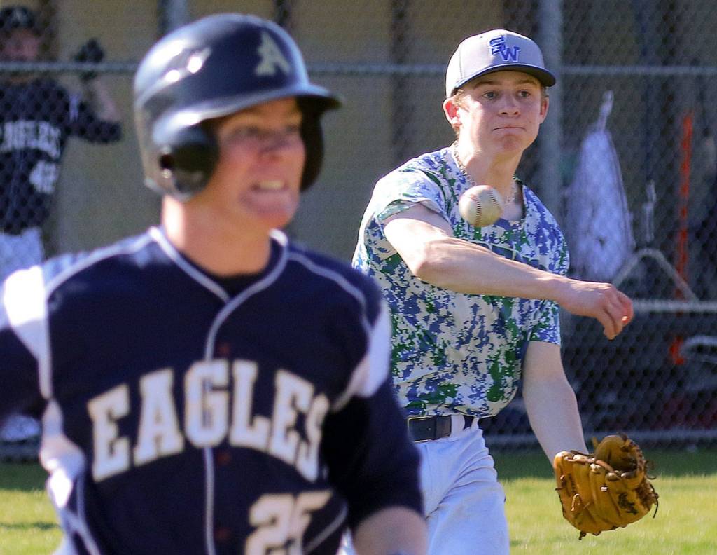 Shorewood&rsquo;s Skyler Manelski throws to beat Arlington&rsquo;s Andrew Smith at first base during a game April 21, 2017, in Arlington. (Kevin Clark / The Herald)