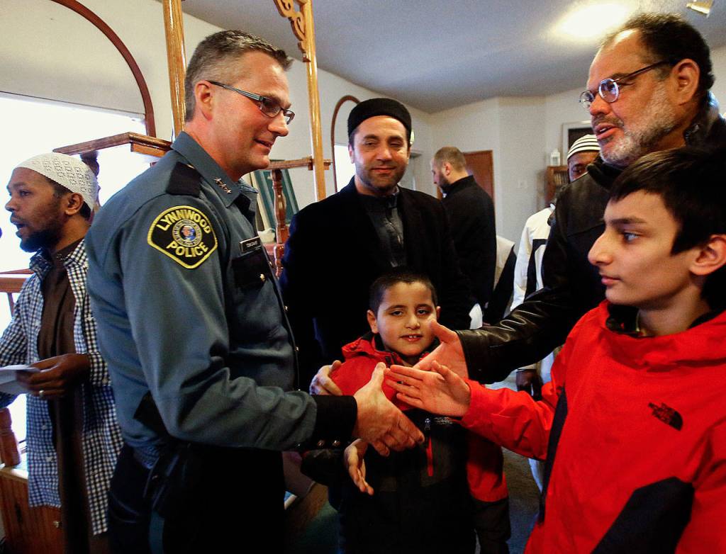 After speaking to a large crowd at the Evergreen Islamic Institute, then-acting Lynnwood Police Chief Tom Davis is greeted warmly by individuals and families earlier this year. Davis spoke on the subject of immigration policy and how the police department and Muslim community can work together. (Dan Bates / The Herald)