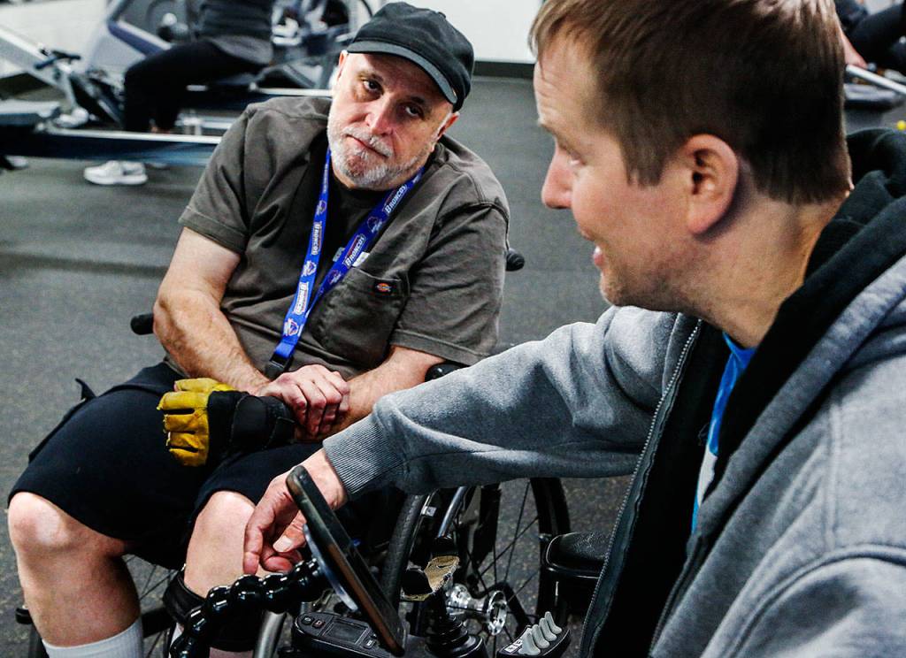 Scott Ballenger stops to talk with Duitsman and observe some of his workout. (Dan Bates / The Herald)