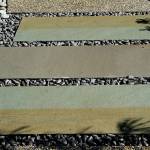 A path made of concrete slabs with black beach pebbles lead to a patio. (Pam Roy photo)