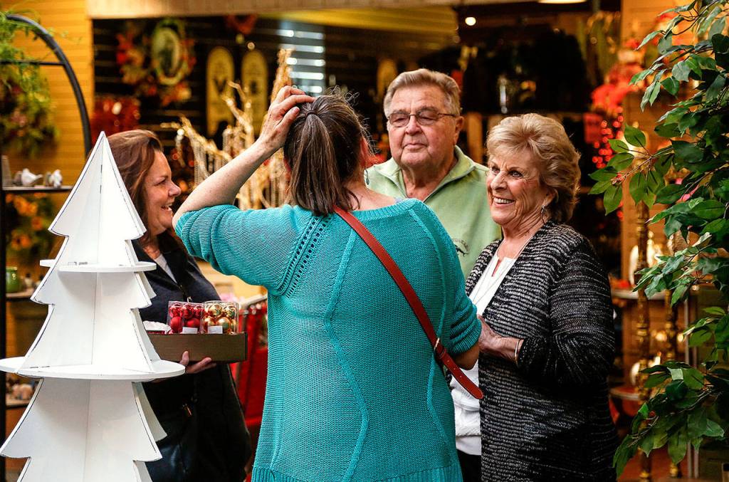 Longtime customers and friends, Victoria Friar (left), and Nancy Sewell, both of Edmonds, get a chance to talk with Jim and Dorothy Anderson Friday morning as the store filled with shoppers taking advantage of the price cuts on the unique inventory. (Dan Bates / The Herald)