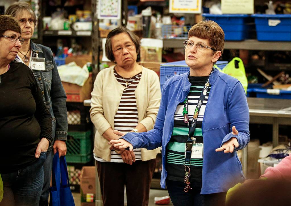 Amy Howell, Assistant Director and Program Manager at the Marysville Community Food Bank, announces to her volunteers that funding may potentially dry up during a food packing session on Thursday, April 27. (Ian Terry / The Herald)