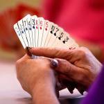 Linda Rubadue, 78 (foreground) studies her cards while Dolores Lemmon, 82 (in pink) does so in the background during duplicate bridge play at the Everett senior center April 4. Because the number of players has shrunk over time, the center plans to conduct how-to classes in hopes of boosting numbers and stirring interest in the card game among a new generation. (Dan Bates / The Herald)