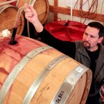 Ryan Kramer uses a wine thief for a sample at Dusky Cellars on Camano Island Sunday February 4, 2017. (Kevin Clark / The Herald)