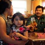 Justina Hernandez-Antonio, holding Maritza Martinez-Hernandez, toasts with her husband Eutiquio Martinez-Garcia in their dining room.                                (Kevin Clark / The Herald)