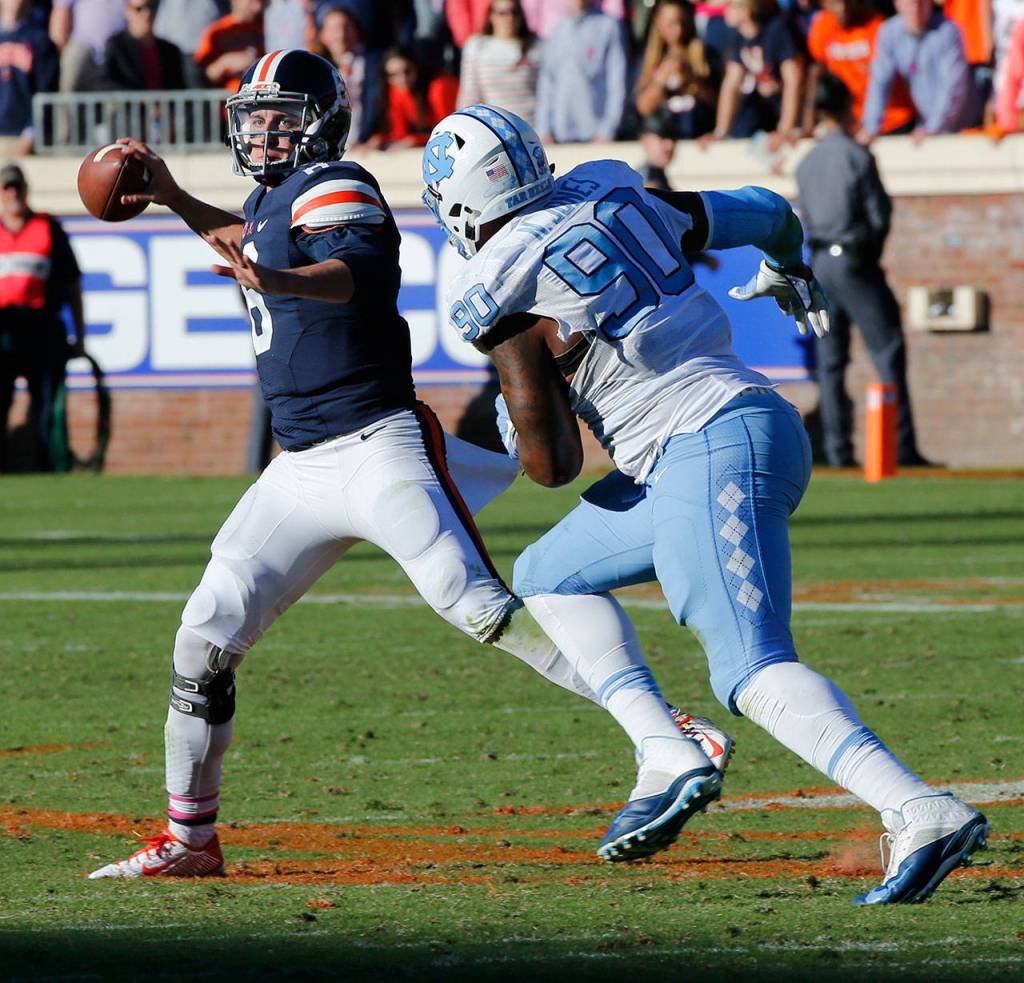 Virginia quarterback Kurt Benkert (6) makes a toss as North Carolina defensive tackle Nazair Jones (90) closes in during the first half of a game Oct. 22, 2016, in Charlottesville, Va. (AP Photo/Steve Helber)
