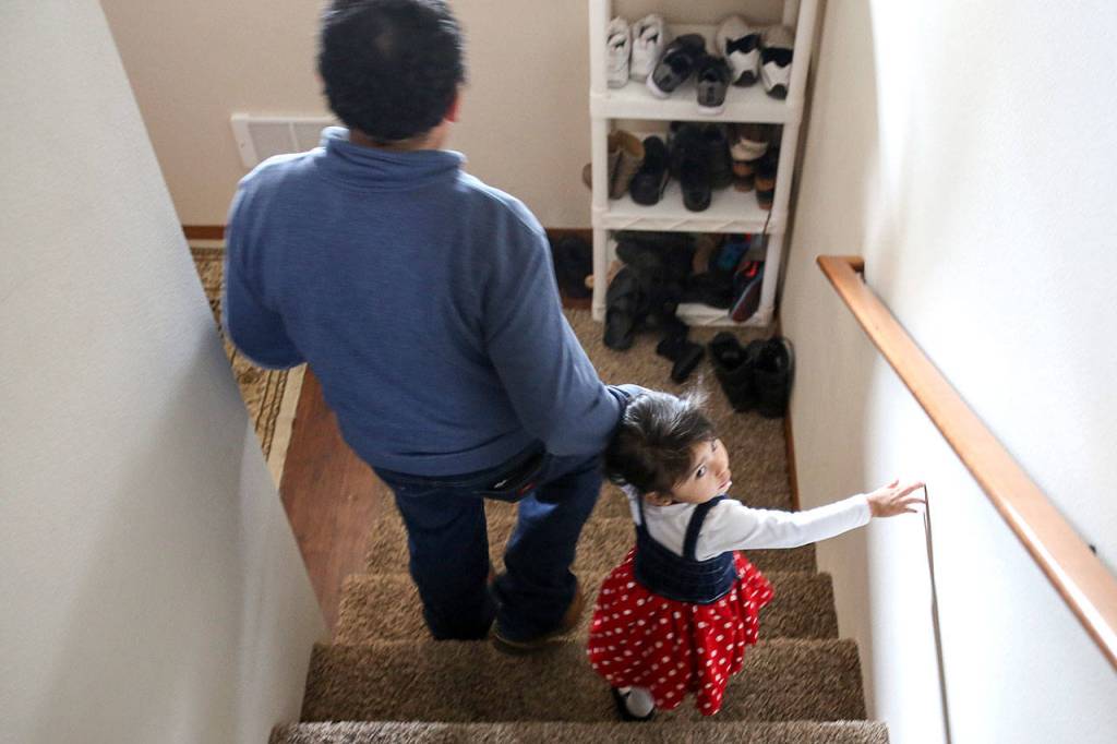 Eutiquio Martinez-Garcia and Maritza Martinez-Hernandez make their way downstairs in their new home.                                (Kevin Clark / The Herald)