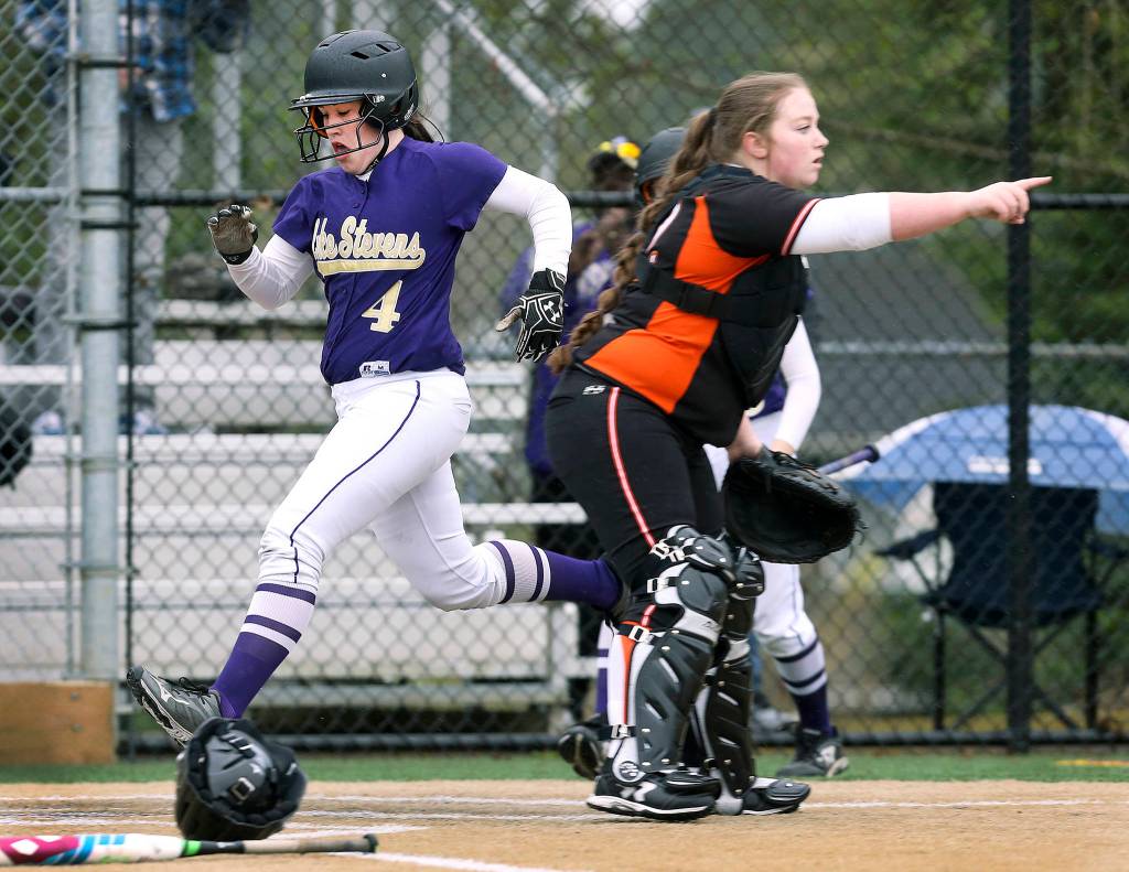 Lake Stevens&rsquo; Camryn Dubois scores a run as Monroe&rsquo;s Taylor Durant points to second base in Lake Stevens&rsquo; win over Monroe, 2-0, in a fastpitch game April 17 in Lake Stevens. (Andy Bronson / The Herald)