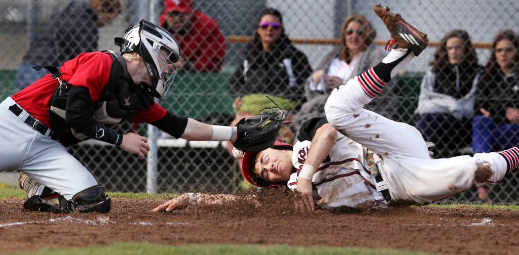 Snohomish&rsquo;s Josh Johnson beats the tag by Marysville Pilchuck catcher Jordan Luton as Snohomish wins, 4-3, in extra innings of baseball April 18 in Snohomish. (Andy Bronson / The Herald)