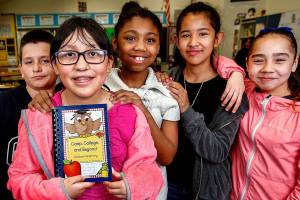 Along with their Madison Elementary School classmates, Jaedin Chum (left), Alfonso Moreno, Jaimy Moreno, Jaila Snowden, Daisy Padilla and Julissa Lopez are selling cookbooks with recipes from their teachers and parents to help pay their way to Camp Orkila on Orcas Island for fifth-grade outdoor camp. Jaimy Moreno, holding the cookbook (center), is tied with one other fifth-grader in sales thus far. (Dan Bates / The Herald)