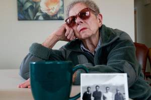 Everett&rsquo;s Doris Sinclair, 88, reflects on a chilling experience she had while traveling by train from Iran to Soviet Georgia in 1964. Detained by Soviet authorities, she was interrogated for three days before being allowed to continue with her trip. Sinclair and her husband, who was in the U.S. Air Force, lived in Iran from 1963 to 1968. In the foreground is a photo of several men in Iran, one of whom was her driver in those years. (Dan Bates / The Herald)