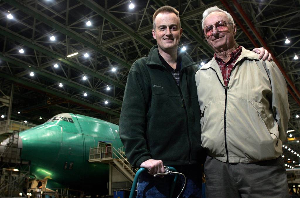 Darin Mang (left), a sparekitting engineer, and his father, Calvin Mang, a retired Boeing engineer, pose in the 747 bay at the Everett plant in 2006. Calvin worked on the original Boeing 747. (Kevin Nortz / The Herald)