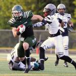 Arlington running back Jeff Hanson avoids the reach of Cowlitz Cobra defender Daniil Karpyuk on his way to a touchdown Saturday during the Grizzlies&rsquo; season opener at John C. Larson Stadium in Arlington. (Doug Ramsay / For The Herald)