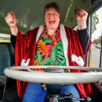 A delighted Sue Cheffer climbs into the driver&rsquo;s seat of a vintage Crown Motor Coach school bus when fellow drivers at Everett School District&rsquo;s bus barn at 37th and Oakes surprised her with a party and a ride Wednesday, just two days before her retirement. (Dan Bates / The Herald)