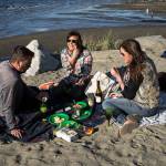 Andrew Gaston, Julissa Downing, and Kelly Colman enjoy a picnic at Edgewater Beach in Mukilteo. Colman owns Proper Picnic, a company that sells ready-to-go picnics. (Andy Bronson / The Herald)