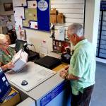 At the Silvana Post Office on Thursday morning, SSA clerk Debbie Nield helps Dwaine Howe, of Camano Island, mail a package. (Dan Bates / The Herald)