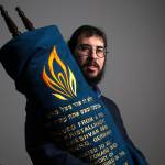 Rabbi Berel Paltiel holds a Torah, rescued from a burning building during Kristallnacht, the Night of Broken Glass, in 1938 in NaziGermany, at the Chabad Jewish Center of Snohomish County on Tuesday. This Torah will be read during the Jewish holiday of Shavuot,which began Tuesday and ends Thursday. (Andy Bronson / The Herald)