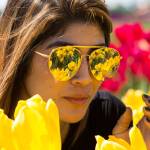 The tulips fields at Tulip Town are reflected in the mirrored sunglasses worn by Silvia Iraheta, of Bellingham, on Thursday in Mount Vernon, Wa. The Skagit Valley Tulip Festival ends Sunday. (Andy Bronson / The Herald)