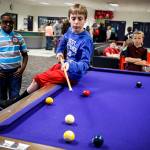 Cory Middleton (center), 11, lines up a shot while playing pool with his friends at the Arlington Boys & Girls Club on Tuesday. Recent renovations have been completed and include a new gym, a teen center and updated facilities. (Ian Terry / The Herald)