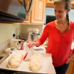Joyce Sieben coats her cardamom bread with an egg wash before baking the braided loaves at her home in Bothell. (Ian Terry / The Herald)