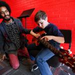 Jonah Jacobs (right), of Lynnwood, gets a beginner guitar lesson from Dominique Hall, of Lynnwood, during an open house at the new Lynnwood School of Rock. (Ian Terry / The Herald)