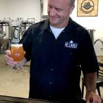 Jim Weisweaver, co-owner of At Large Brewery, celebrates the one-year anniversary of opening the brewery on the Everett waterfront with a pint of The Chicago Typewriter. The New England-style IPA shares the nickname of Al Capone&rsquo;s Tommy gun. (Photo by Aaron Swaney)
