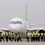 Members of staff stand in front of China&rsquo;s home-grown C919 passenger jet after it landed on its maiden flight at the Pudong International Airport in Shanghai, China, on Friday. (Aly Song/Pool Photo via AP)