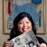Elizabeth Hankins, 46, holds a photo of her and her mother, Peggy Olafson Curtis, taken shortly after she was adopted from a South Korean orphanage, on Monday, May 8 in Everett. Behind her is a framed box with the dress she wore and other memories from Korea. (Andy Bronson / The Herald)