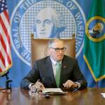 Gov. Jay Inslee sits at a table prior to a bill-signing ceremony on April 19 at the Capitol in Olympia. (AP Photo/Ted S. Warren, file)