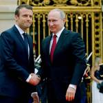 Russian President Vladimir Putin (right) is welcomed by French President Emmanuel Macron at the Palace of Versailles near Paris, France, on Monday. (AP Photo/Alexander Zemlianichenko, pool)