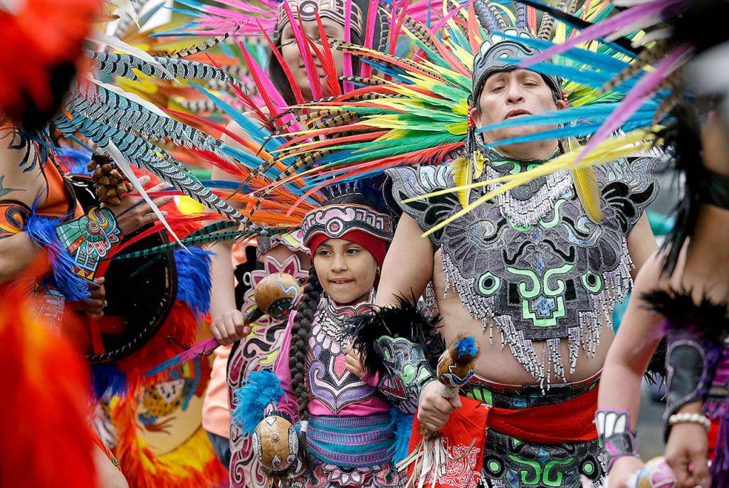 Members of Ce Atl, an Aztec-inspired spiritual and cultural preservation group, dance near the front of a march for worker and immigrant rights at a May Day event Monday in Seattle. (AP Photo/Elaine Thompson)