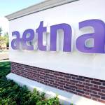 In this 2014 photo, a pedestrian walks past a sign for Aetna Inc., at the company headquarters in Hartford, Connecticut. While Republicans rewrite the Affordable Care Act in Washington, the immediate future of the law has grown hazier with the nation&rsquo;s third-largest health insurer Aetna saying that it will completely divorce itself from state-based insurance exchanges. (AP Photo/Jessica Hill, File)