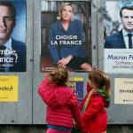 Children walk past election campaign posters for French centrist presidential candidate Emmanuel Macron and far-right candidate Marine Le Pen, in Osses, southwestern France, on Friday May 5. France will vote on Sunday, May 7, in the second round of the presidential election. (AP Photo/Bob Edme)