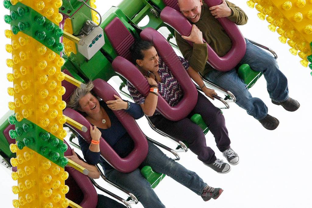 Passengers on the &ldquo;Freak Out&rdquo; ride (from left), Cheryl Bascher of Monroe, Naree Strickland of Mountlake Terrace and John Clarin of Seattle, scream and holler as they sail through the air at the 2015 Evergreen State Fair in Monroe. This year&rsquo;s fair is set for Aug. 24 through Sept. 4. (Herald file photo)