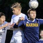 Mariner&rsquo;s Edward Katynskiy heads the ball with Glacier Peak&rsquo;s Camron Miller (left) and Kevin Ramsey challenging during the 4A District 1 title match on May 11, 2017, at Lake Stevens High School. (Kevin Clark / The Herald)