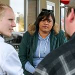 Whitney Hooks, center, listens to the Robert Griffith, right, father of potential client, Rylee Griffith, in Everett on March 31. The four-time state champion shot put thrower from Cascade High School has returned to the area to train and mentor young people. (Kevin Clark / The Herald)