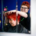 Melissa Castleman (right) smiles as client Corky Montgomery checks out her new red hair color at Eclectik Salon in Everett on Friday, Feb. 17. Castleman specializes in hair coloring at her salon on North Broadway. (Ian Terry / The Herald)