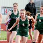 Shorecrest&rsquo;s Sydney Brandt (far right) hands off to teammate Ronna Iverson and Edmonds-Woodway&rsquo;s Hannah Hicks hands off to Gaby Chappell during the 4x100-relay at the Wesco 3A South track and field championships on May 12, 2017, at Edmonds Stadium. (Kevin Clark / The Herald)