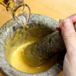 Add the oil, a few drops at a time at first, working it into the garlic and yolk. (Michael Tercha/Chicago Tribune)