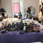Dozens of weapons, along with cash and drugs, were found at a residence in Arlington. (Snohomish County Sheriff&rsquo;s Office)