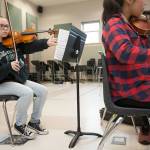 Everett High School&rsquo;s Reilli Hopfauf holds her violin under her chin as she turns pages while playing in the Everett Youth Symphony Orchestra. (Andy Bronson / The Herald)