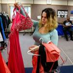 Joslyn Spradley, 18, looks over dresses while her prom date Damion Wilson-Cobbs, 19, holds their month-old son, Avery. (Dan Bates / The Herald)