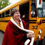 Cheffer steps off a vintage school bus after taking a spin in it, after also having been draped in a royal red cloak. (Dan Bates / The Herald)