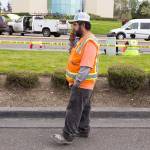 Juan Teran talks on the phone as he waits for his work truck (second from left) to be released from the scene of the plane crash Tuesday in Mukilteo. Burning fuel landed on his truck as he waited for the light at the intersection of Harbour Pointe Boulevard SW and the Mukilteo Speedway.(Andy Bronson / The Herald)