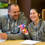 Holding Mikey the monkey, Ivan Ugnivyy and his wife Liliya laugh as she tries to find the right words to say during an ESL class in the library at Emerson Elementary on Monday, May 1, in Everett. The couple are from Ukraine. (Andy Bronson / The Herald)