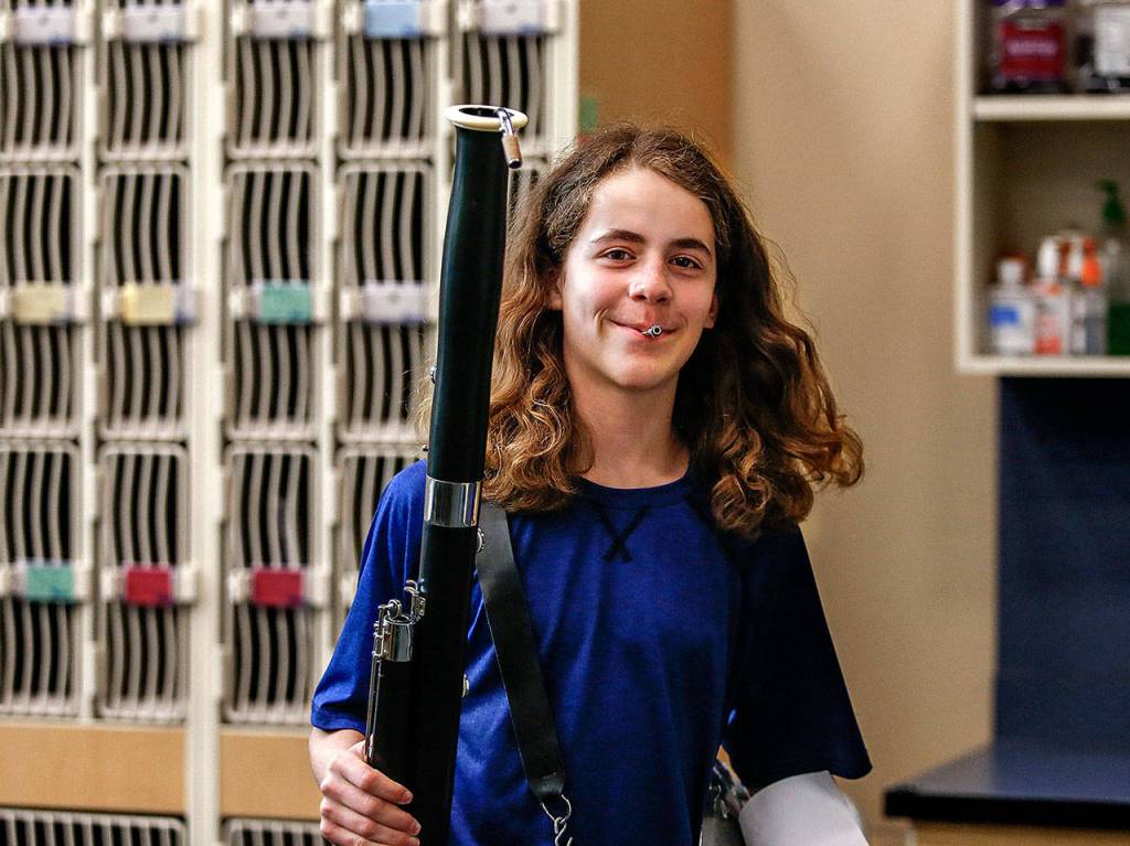 Bassoon in hand and reed moistening between his lips, Elijah Croyle walks from the instrument lockers to his seating position in band practice Wednesday. (Dan Bates / The Herald)