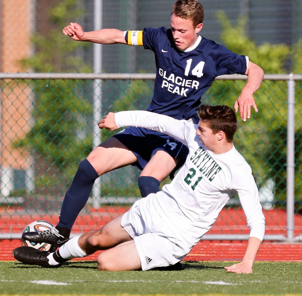 Sammamish&rsquo;s Sam Jarvis makes a slide tackle on Glacier Peak&rsquo;s Miles Johnston during a 4A state playoff match on May 20, 2017, at Skyline High in Sammamish. (Kevin Clark / The Herald)